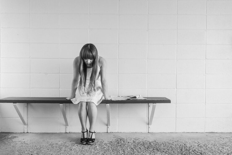 Smutna kobieta z depresją siedzi na ławce