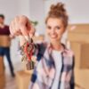 Kobieta trzyma w dłoniach klucze do nowo kupionego mieszkania